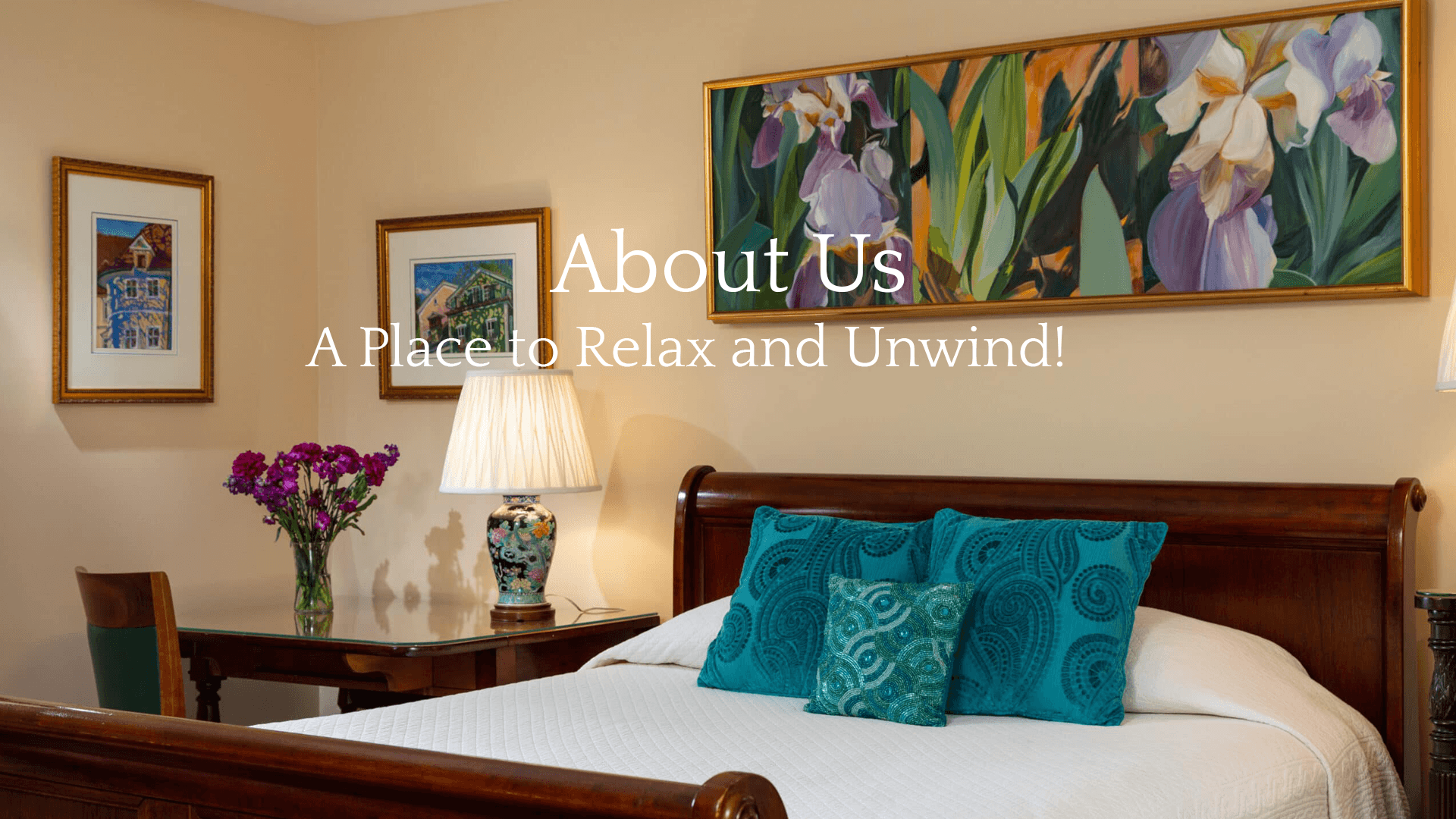 A cozy bedroom featuring decorative pillows, a table with flowers, and colorful artwork on the walls.