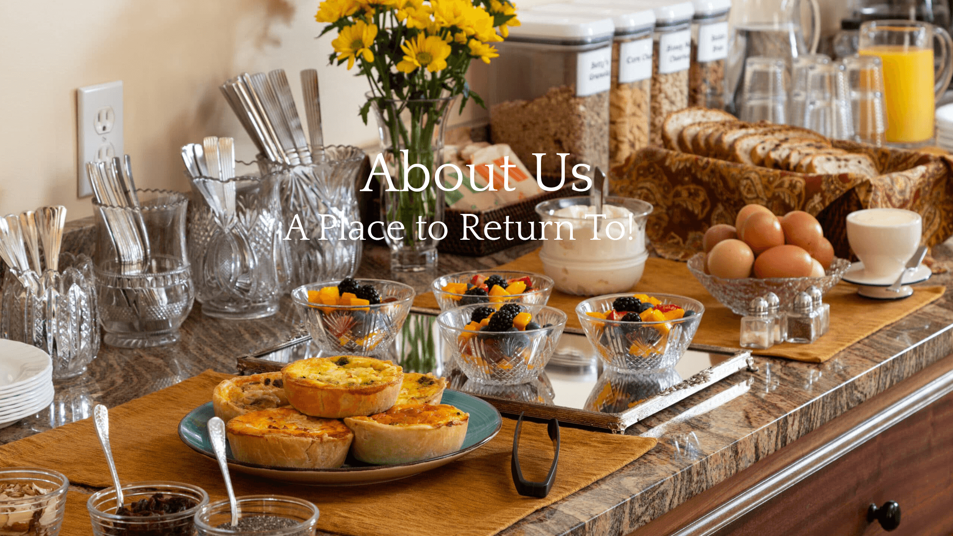 A beautifully arranged breakfast spread featuring fresh fruits, pastries, eggs, and drinks, accompanied by elegant serving ware.