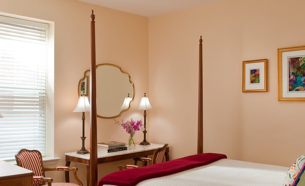 mirror with writing desk and vase of flowers